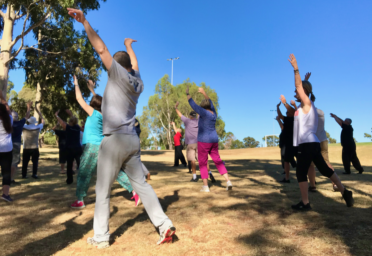 Group of people doing qigong in a park