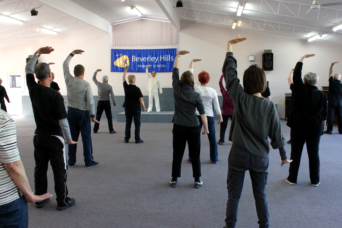 White Crane stretches wings, holding one arm aloft