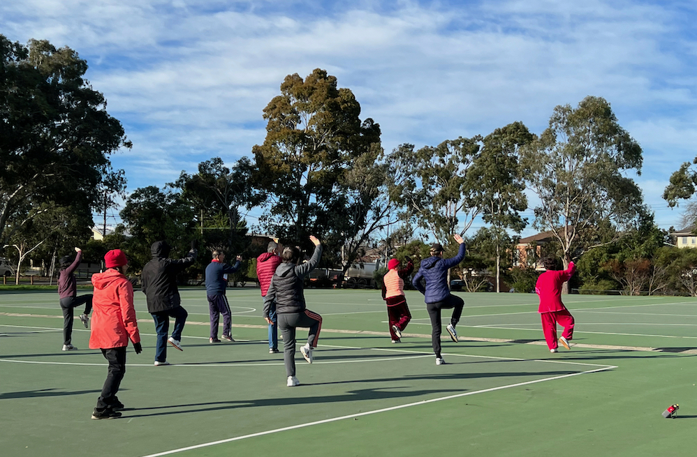 Group doing tai chi on netball courts
