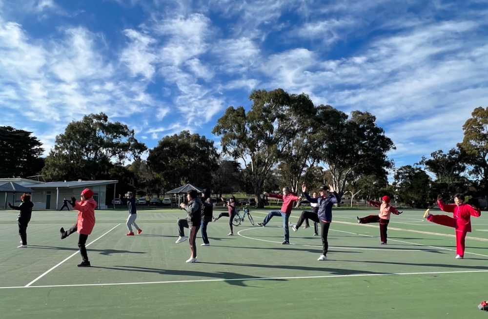 Group doing tai chi on netball courts