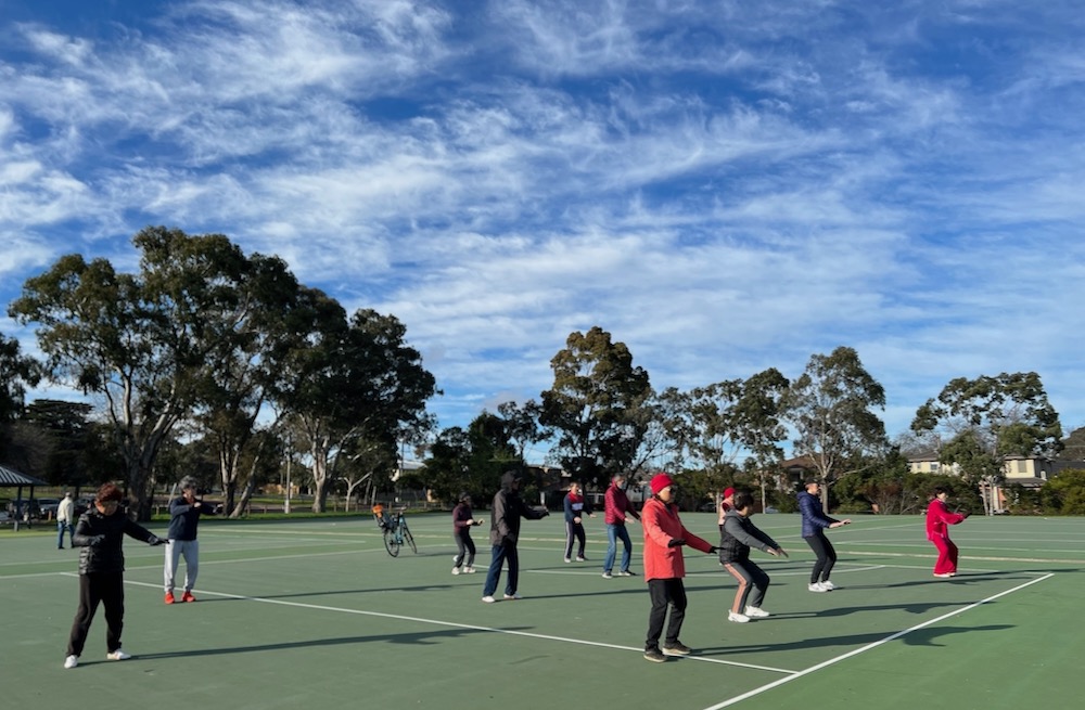 Group doing tai chi on netball courts